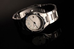 a wristwatch on a black background, with reflection