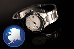 alaska map icon and a wristwatch on a black background, with reflection