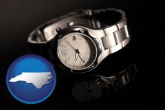 north-carolina map icon and a wristwatch on a black background, with reflection
