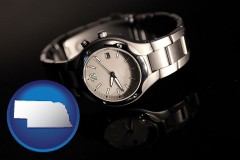 nebraska map icon and a wristwatch on a black background, with reflection